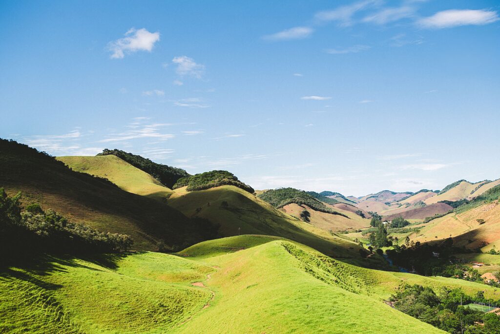 Vibrant green hills rolling under a bright blue sky, perfect for nature and travel inspiration.